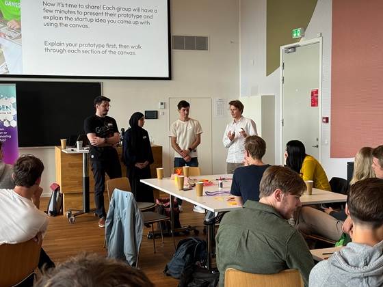 Fire studerende præsenterer i et klasselokale